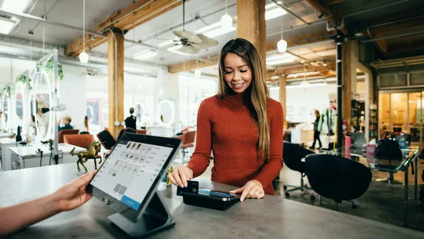 Women scratching card on card machine.