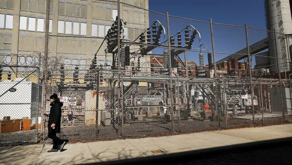 A person walks by a power plant