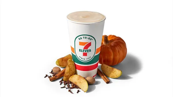 A photo of a 7-Eleven to-go cup surrounded by spices and a pumpkin against a white background. The cup reads "OG To-Go 7-Eleven since 1964."