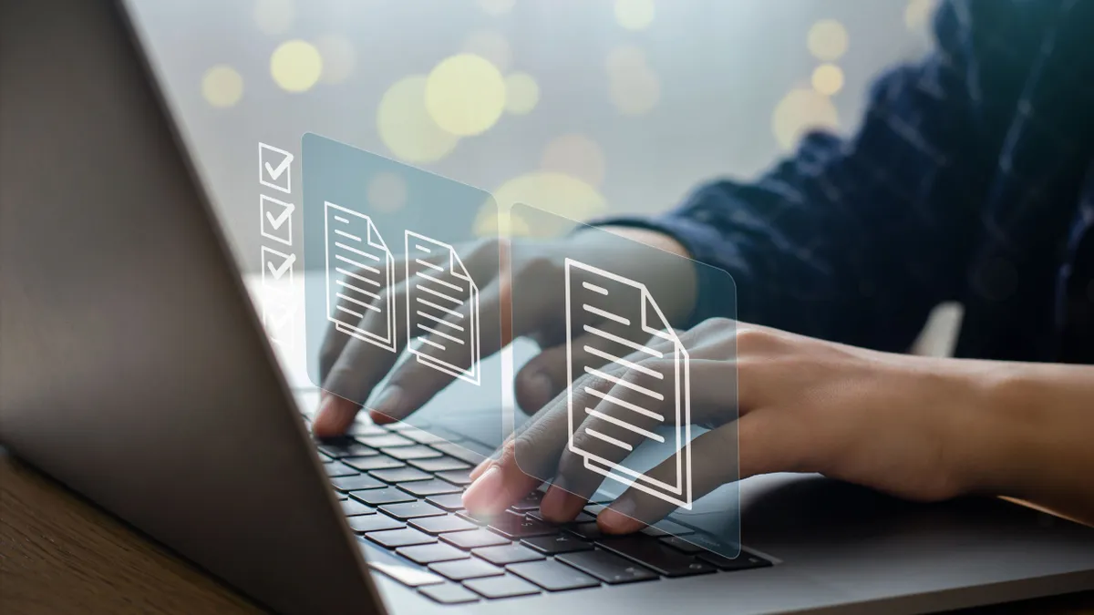 A businessperson uses a laptop to manage documents