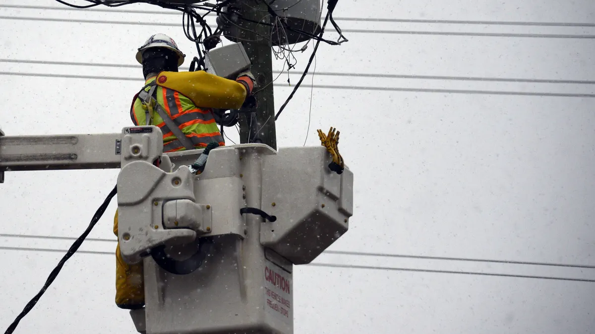 An electrical worker makes repairs on a utility pole during a snow storm on January 17, 2018 in Raleigh, North Carolina.