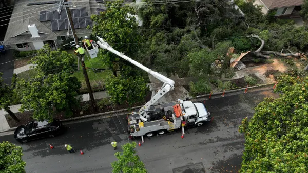Utility workers repair an electrical line.