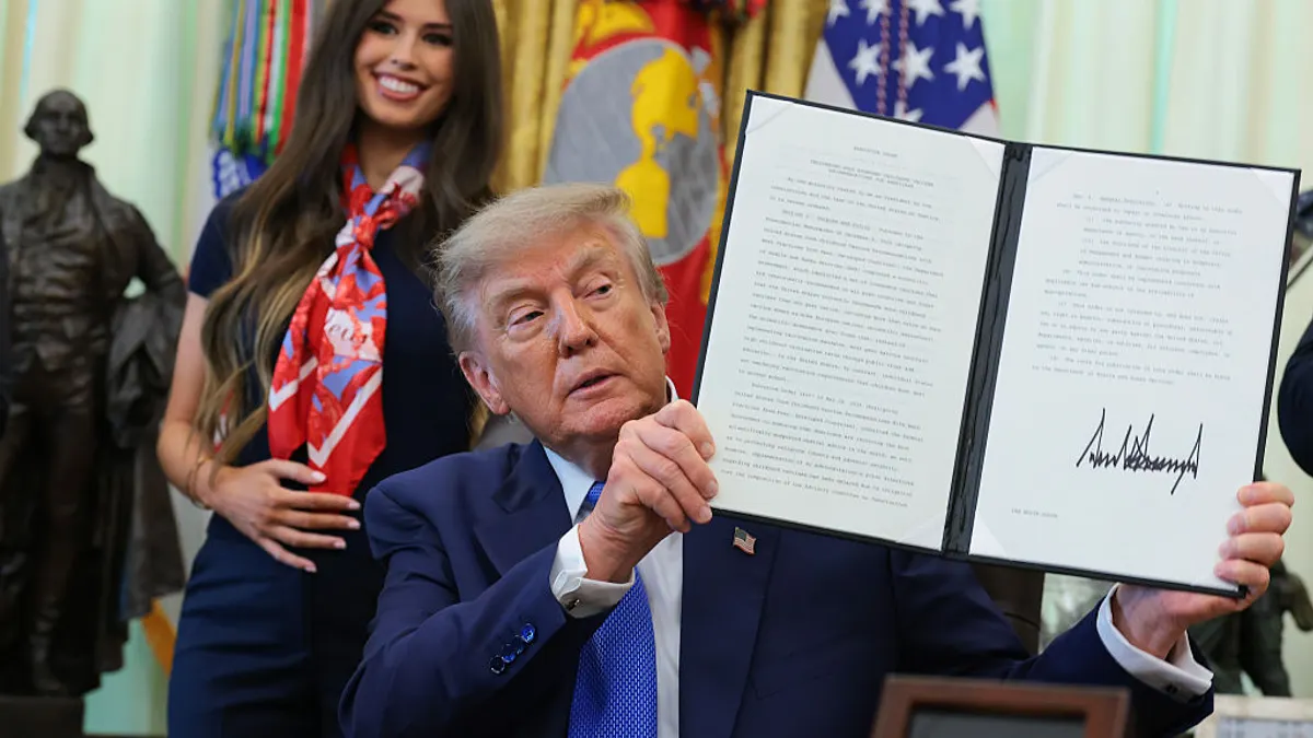 President Trump holding up an executive order on vaccines.