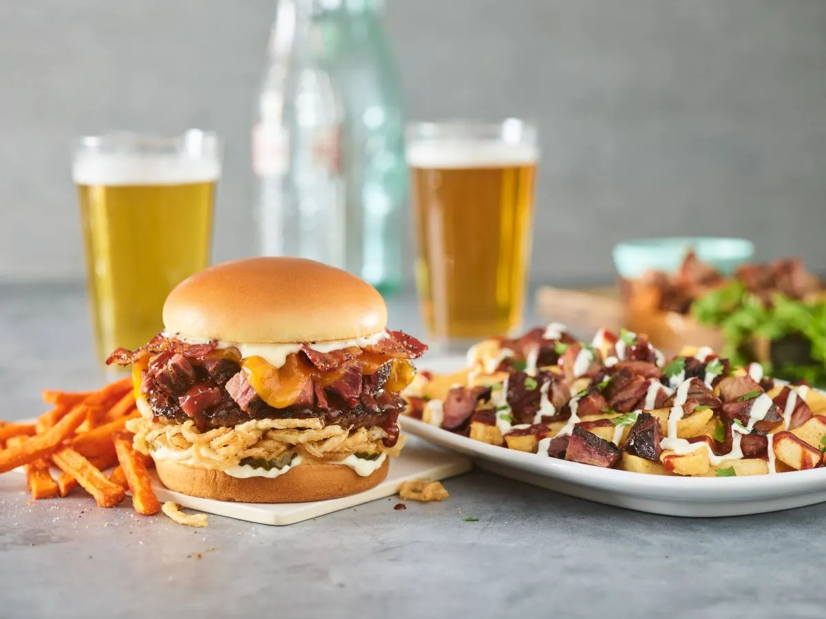 A barbecue burger and loaded fries from Red Robin on white plates