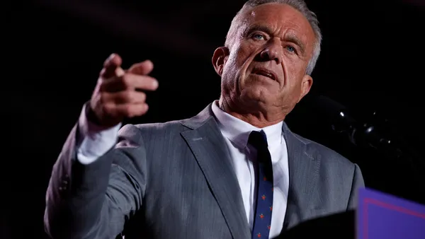 RFK Jr. points a finger during a speech behind a podium