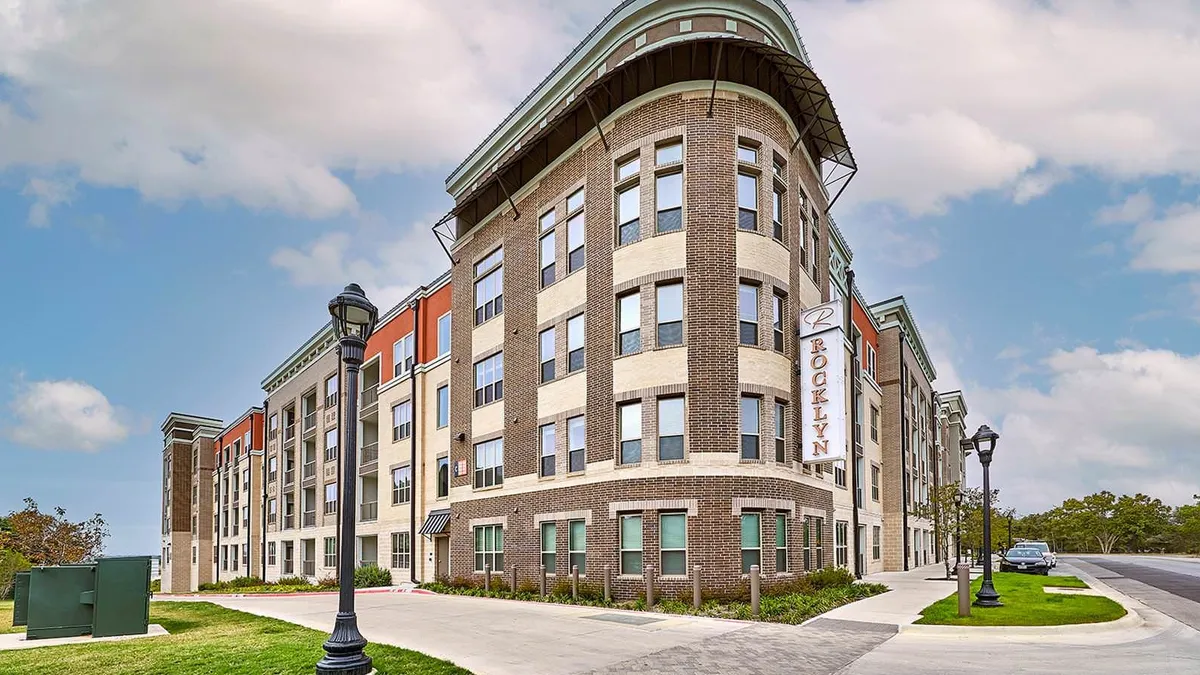 Brown brick apartment buildings with streets in the foreground.