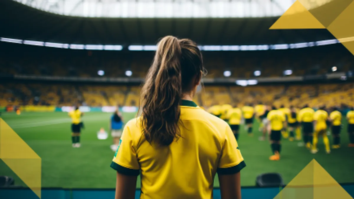 back of person with a ponytail looking out onto soccer stadium field