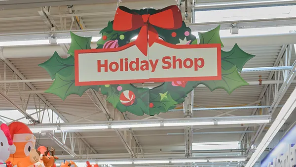 An interior store sign with holiday colors saying "Holiday Shop"