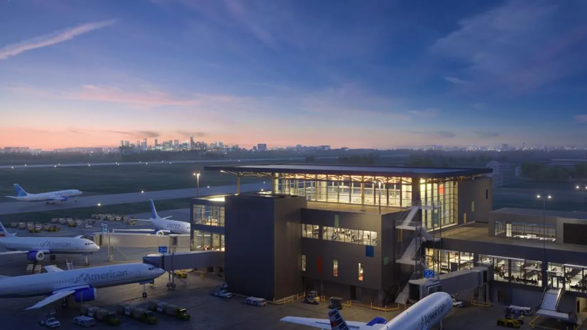 Nighttime view of a glassy building surrounded by airplanes.