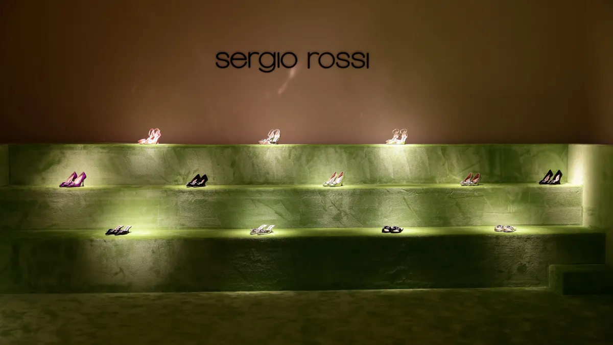 High-heeled shoes on display underneath a sign that reads Sergio Rossi.