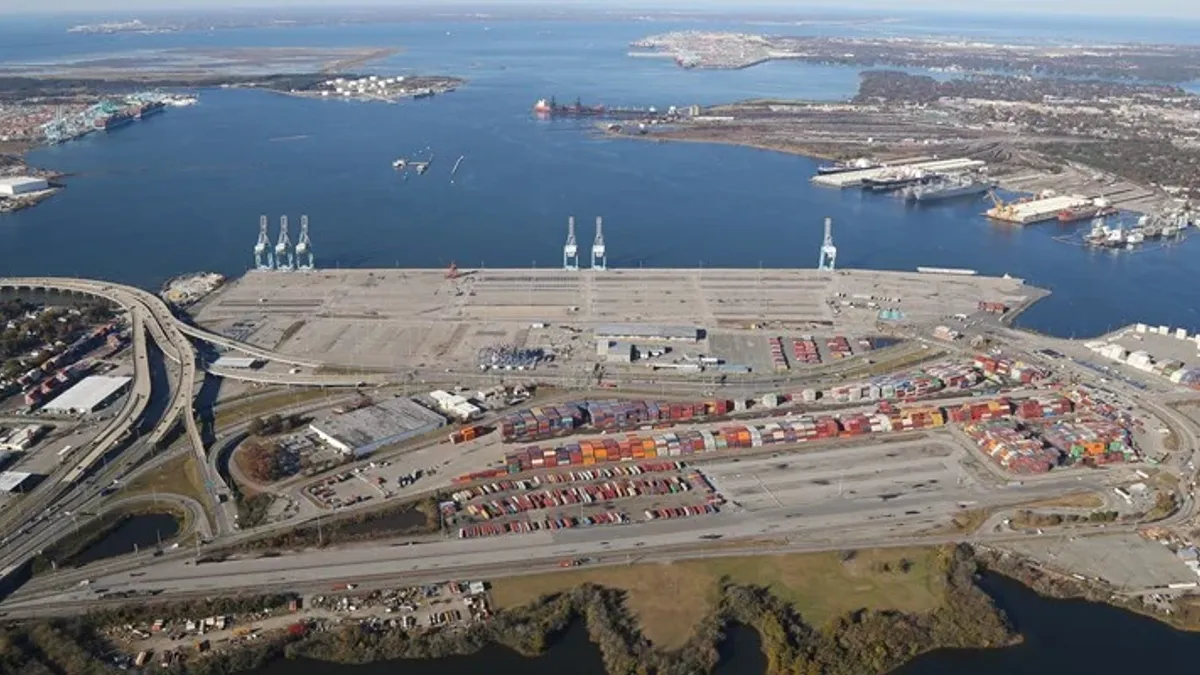 An overhead view of waterfront offshore wind turbine construction.