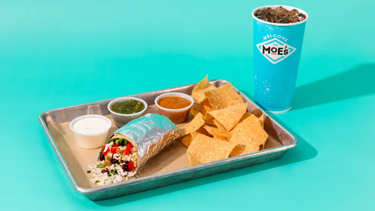 A burritio, chips, drink, side of queso and some salsas.