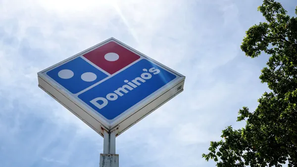A diamond sign with red and blue and a white words that say "Domino's"