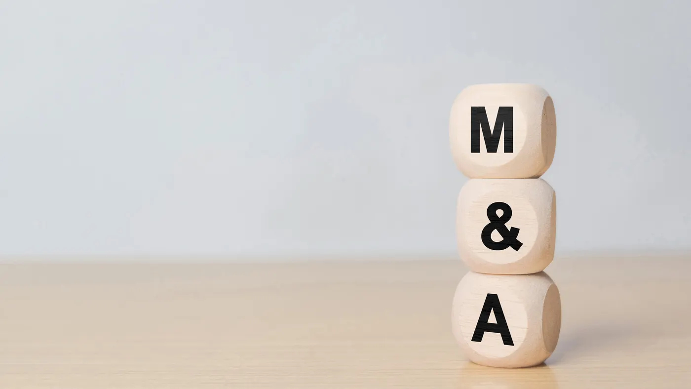 Three stacked wooden cubes on the right side of the frame read "M&A"