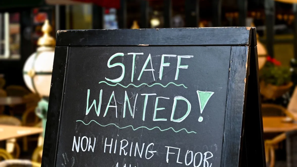 An image of a sign saying "Staff wanted" at a restaurant.