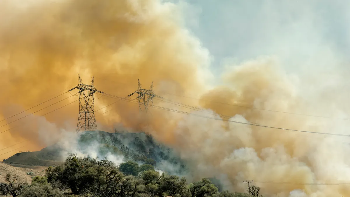 Electric transmission lines covered in smoke from a wild fire.