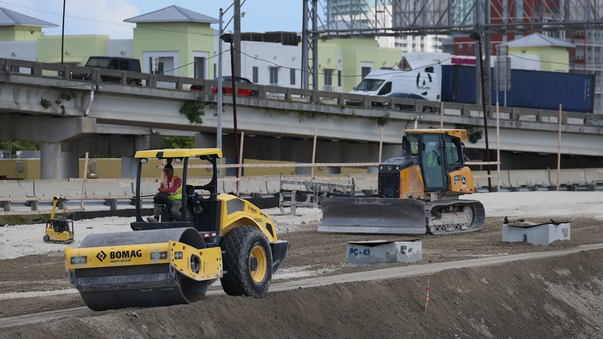 Highway construction site with work vehicles.