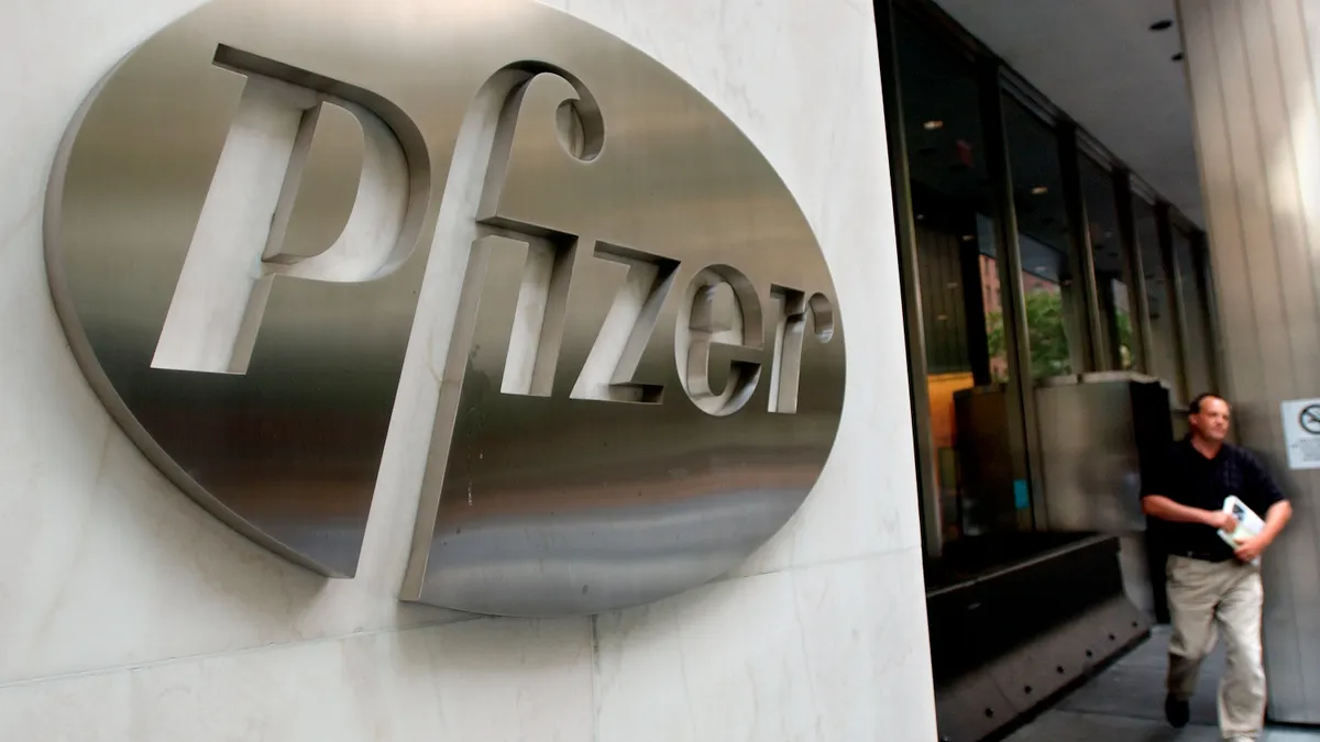 A man walks out of the Pfizer world headquarters building.