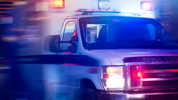 An ambulance in motion with lights flashing.