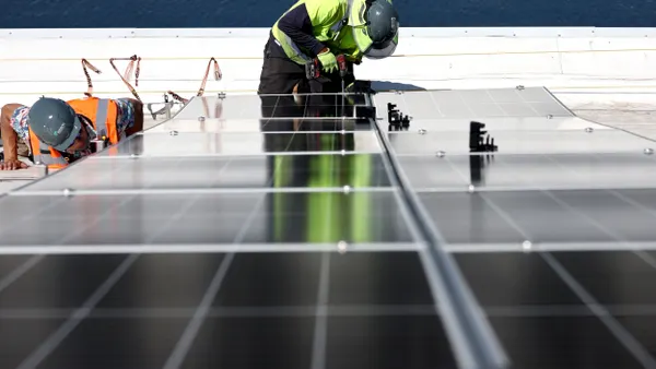 Workers install solar panels