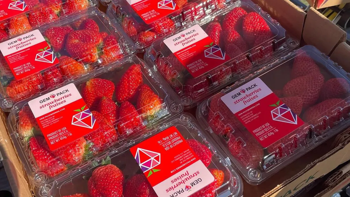 Close-up view of clear, plastic containers with strawberries inside.