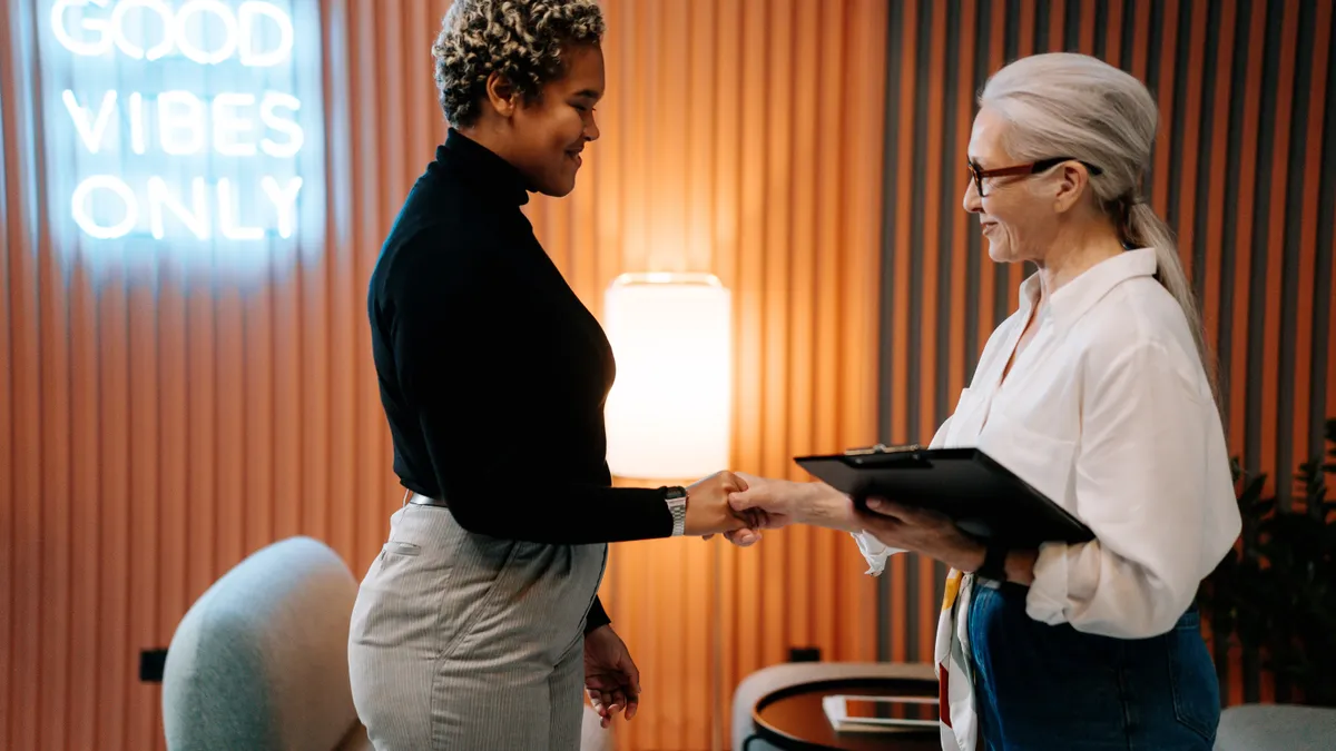 A woman shakes the hand of her job interviewer