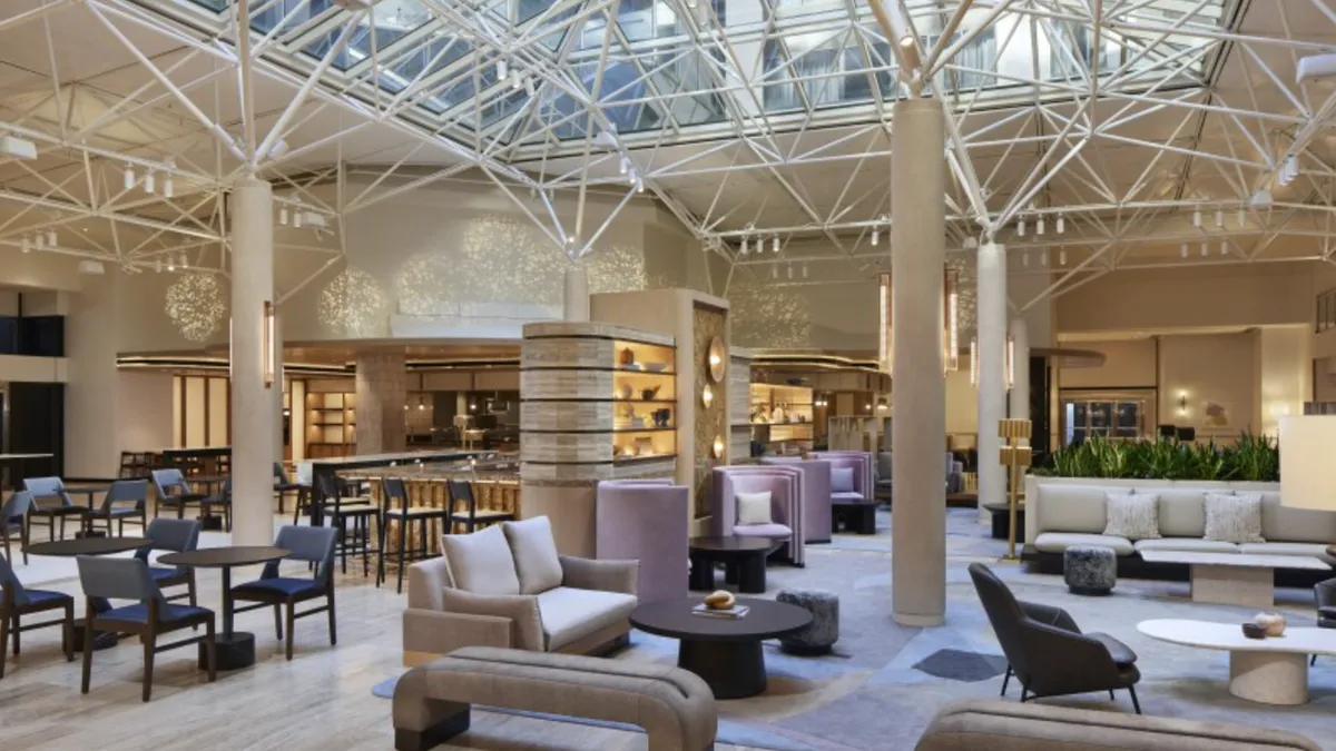 The lobby features beige furniture and a windowed ceiling.