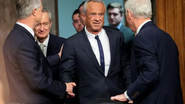 Robert Kennedy shakes hands with members of the senate finance committee