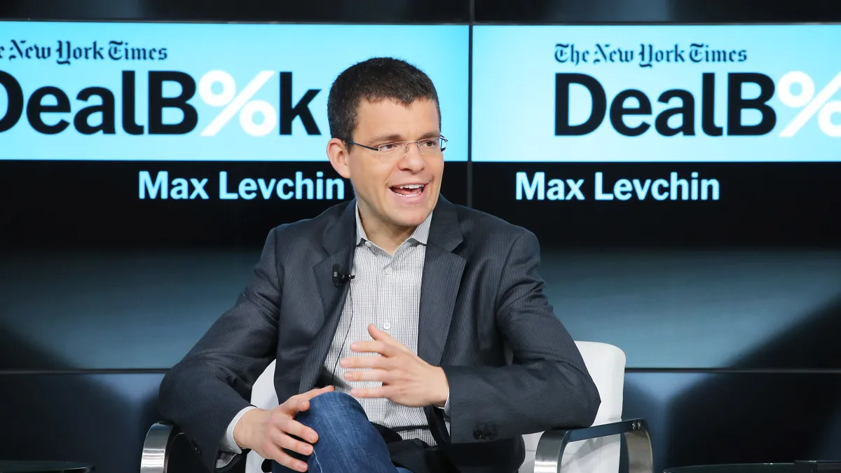 Seated man speaking with New York Times logo in background and the name 'Max Levchin'