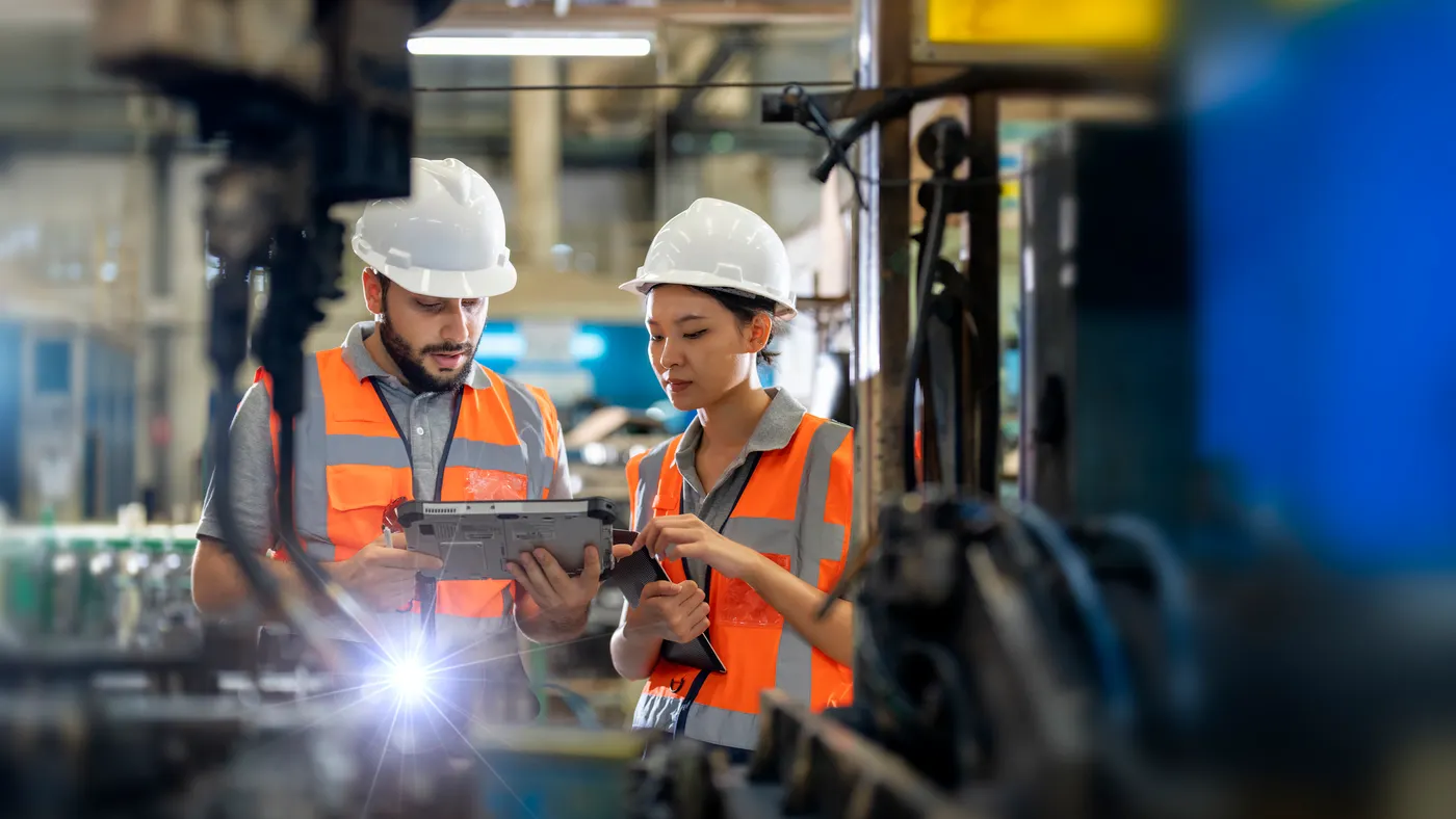 Engineers observing the Robotics arm welding units operation at factory.