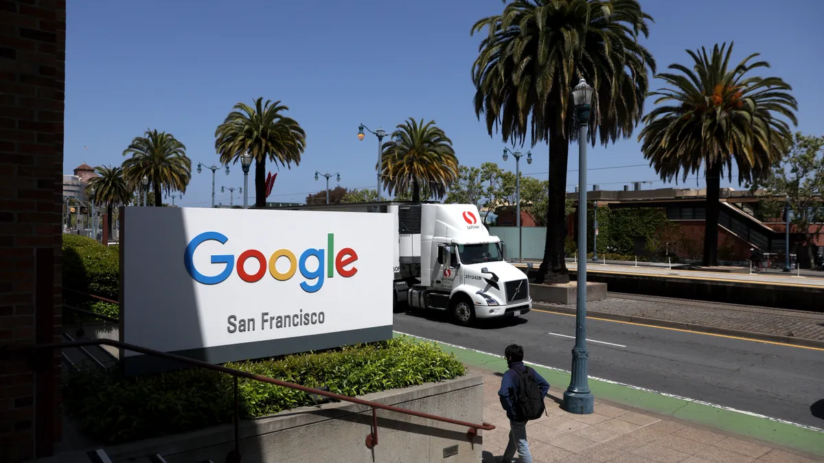 Truck driving past entrance with Google sign.