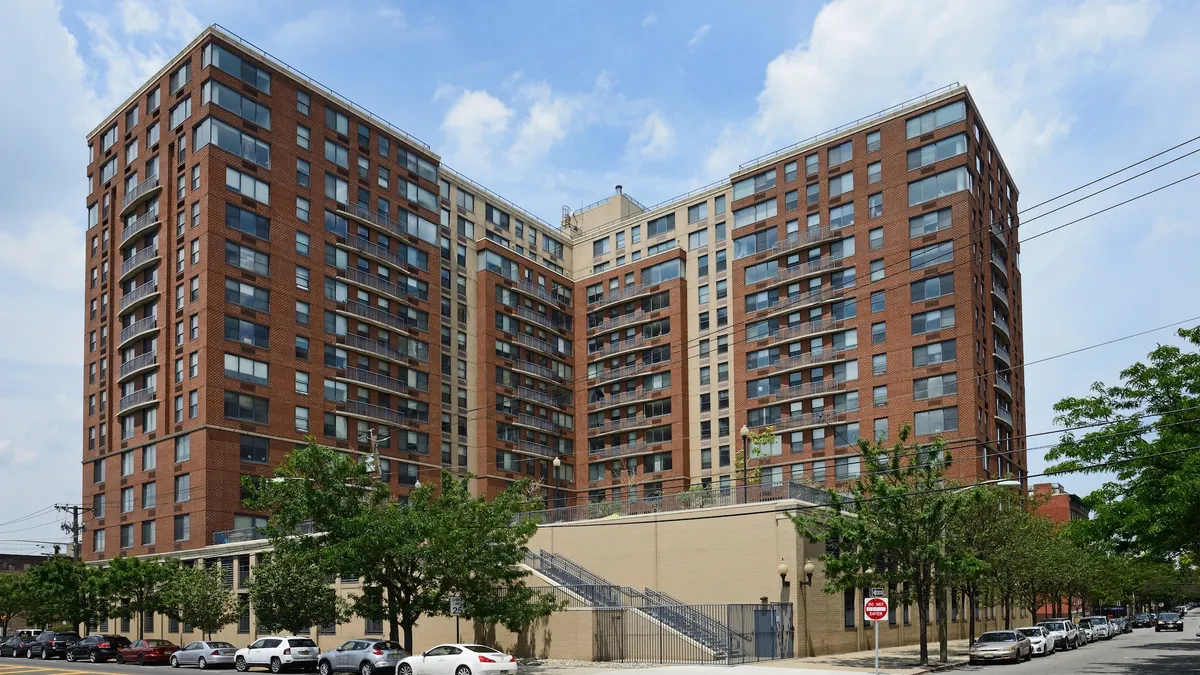 Ground level picture of brick, high-rise apartment building