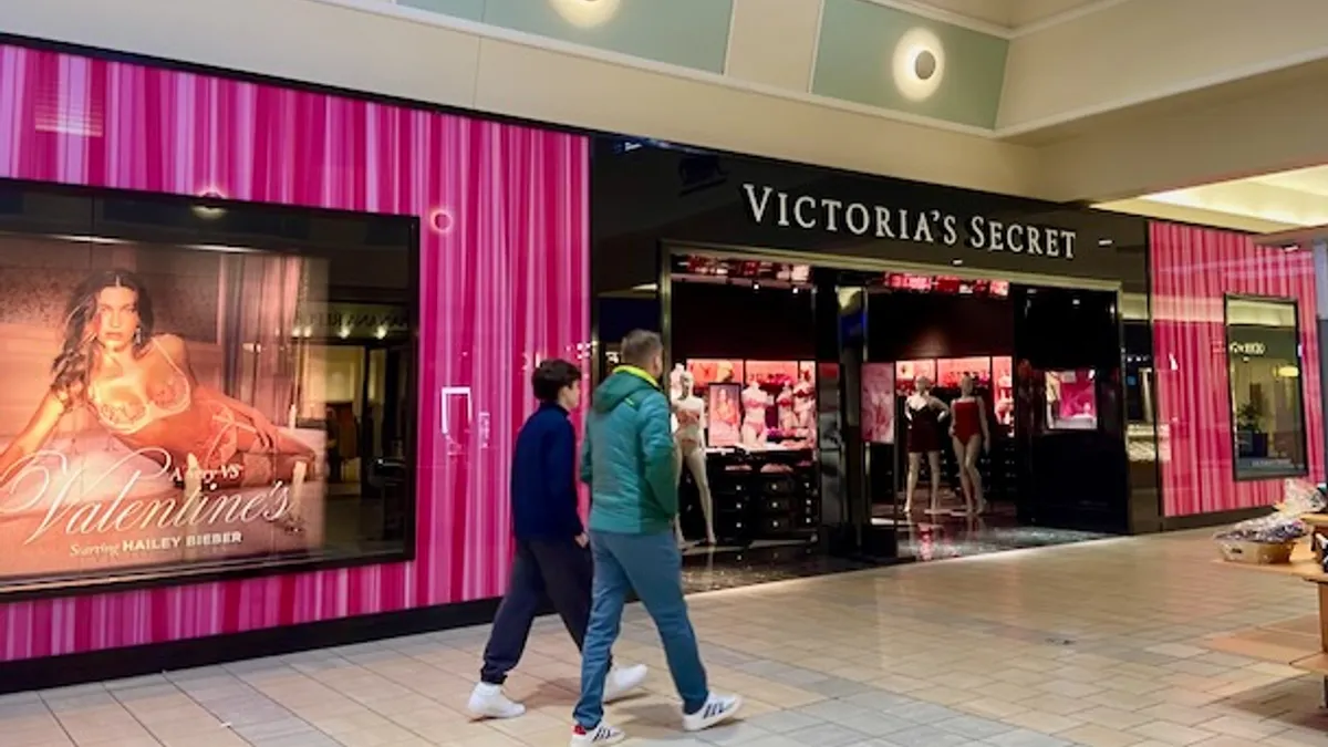 People walking past a mall store.