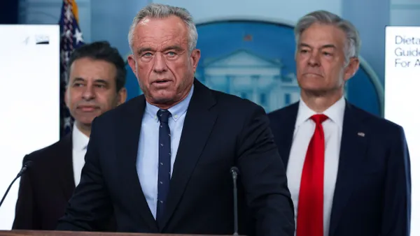 Robert F. Kennedy Jr. stands at a podium that has "The White House" written on it.