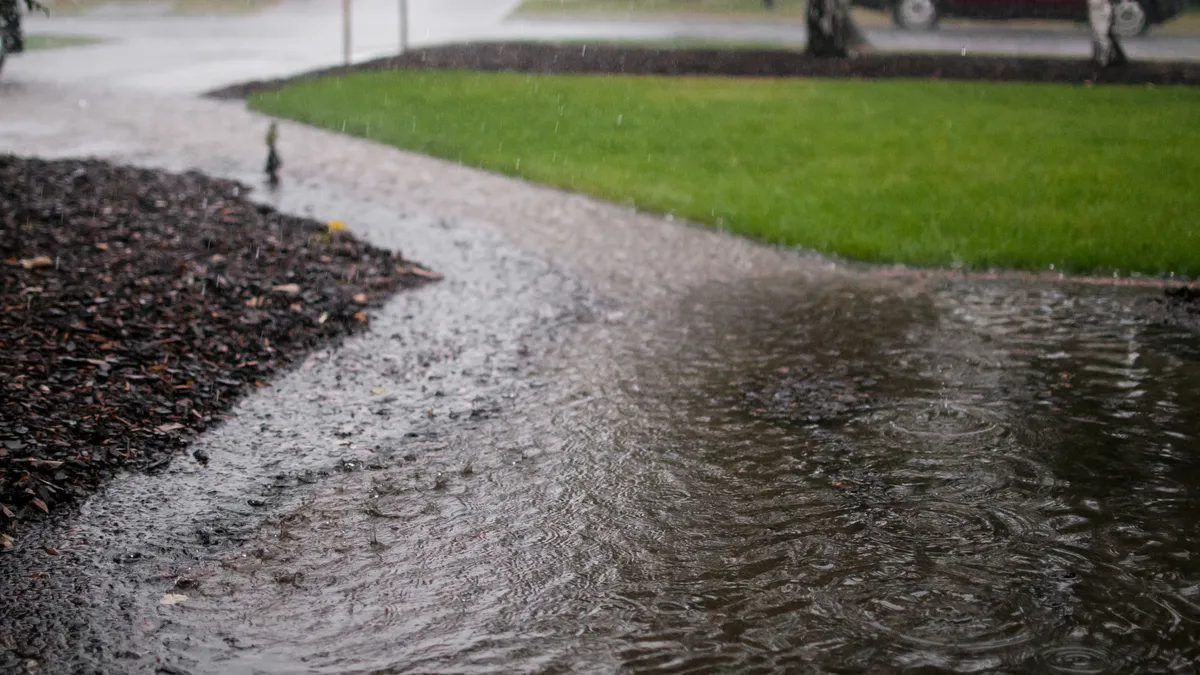 Heavy rain creates deep puddles in a neighborhood.