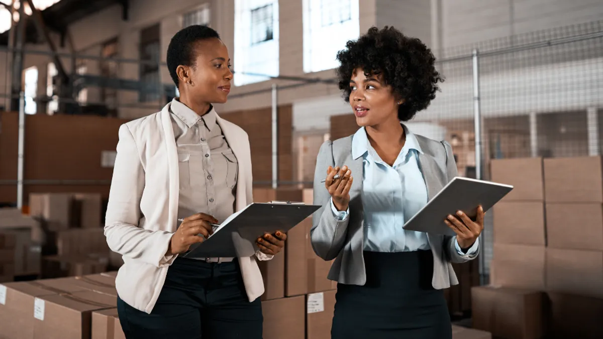 Two people working together in front of boxes