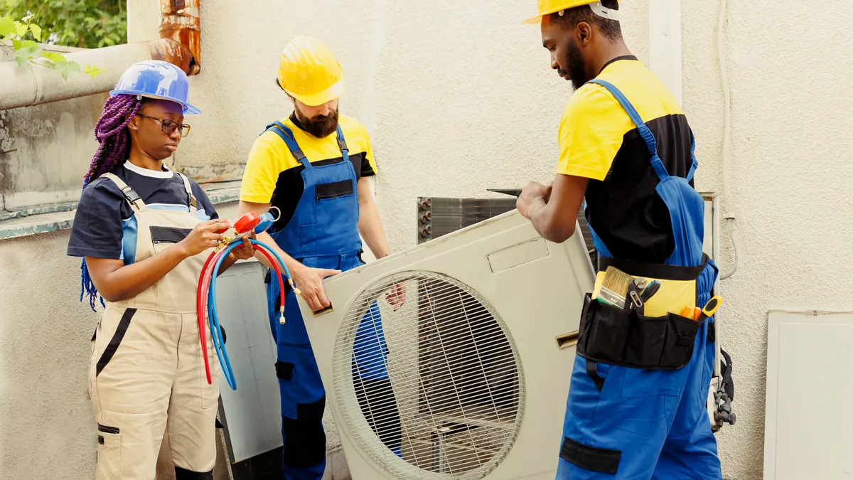 Technicians work on an HVAC unit.