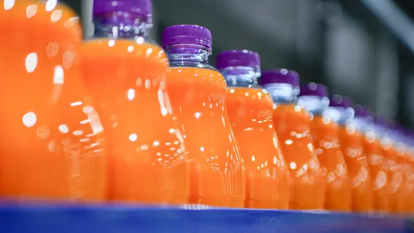 Orange juice in bottles on a production line.