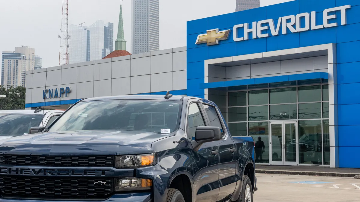 A pickup truck parked in front of a Chevrolet dealership in Houston, Texas.