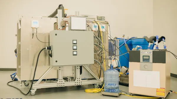 Machine with hoses and wires, several water containers and a heat pump
