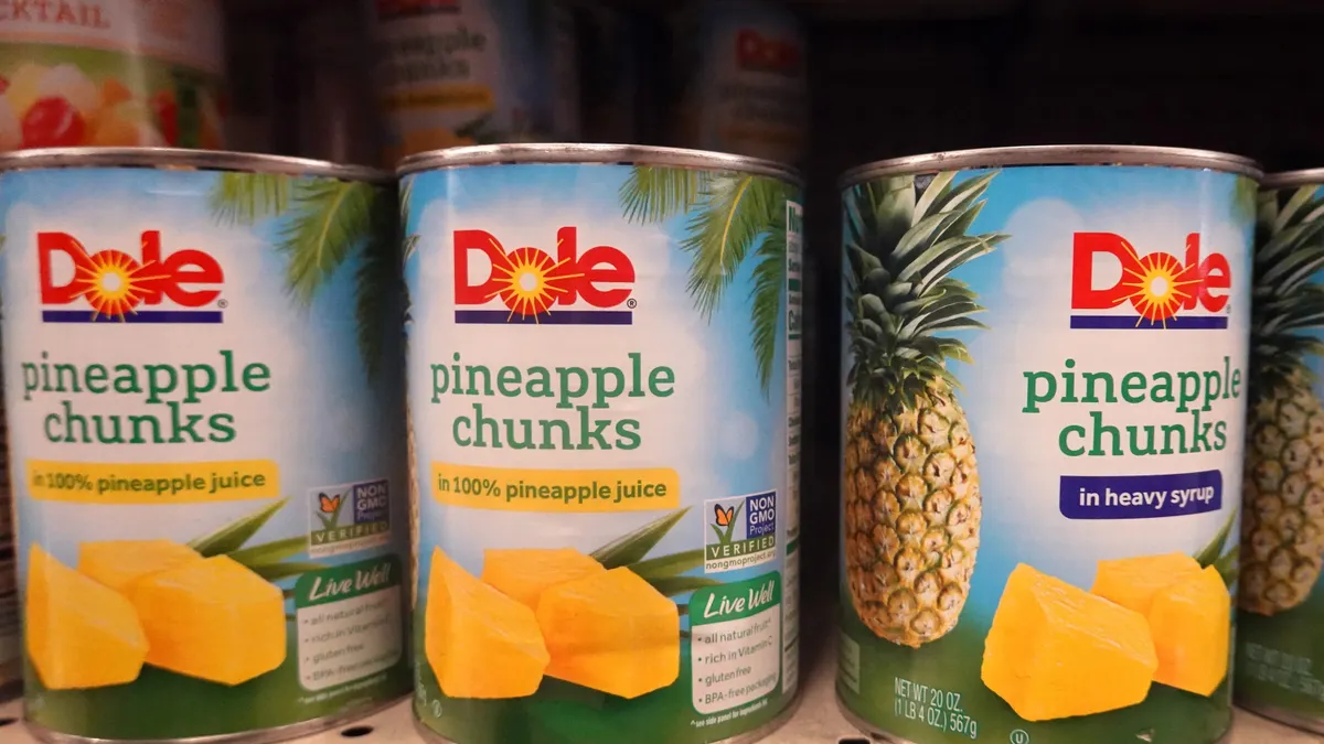 Cans of pineapple chunks sit on a shelf at a grocery store on July 26, 2021, in Chicago. The cans read "Dole pineapple chunks in 100% pineapple juice."