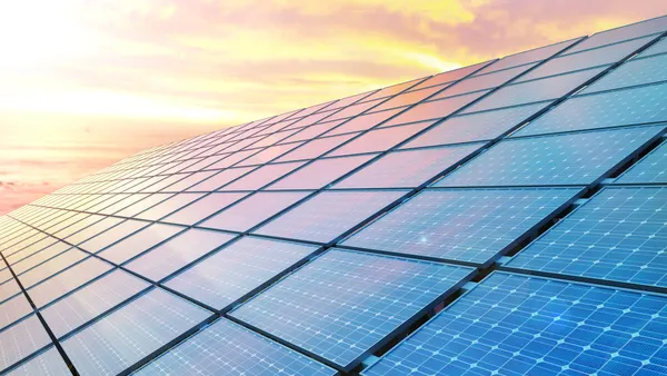 Solar panels reflect a sunrise.
