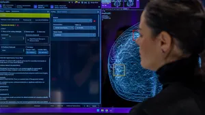 A person looks at a screen that shows an image of tissue with squares in yellow and red.