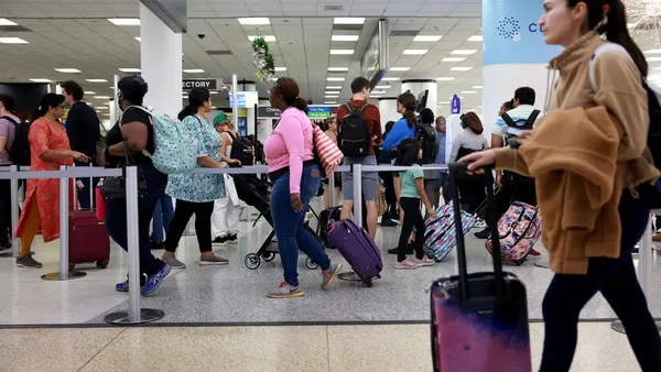 Travelers stand in line for a TSA checkpoint at the Miami International Airport on December 19, 2022 in Miami, Florida.