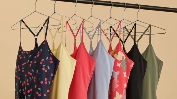 A row of colorful exercise dresses on hangers.