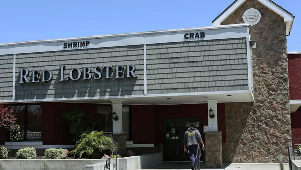 A customer walks up to a closed restaurant with a logo that says "Red Lobster"