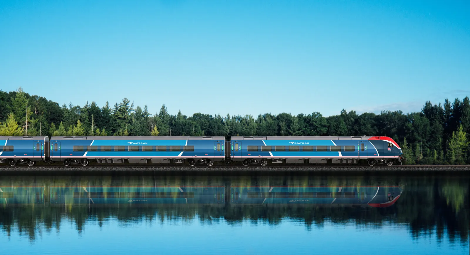 A sleek Amtrak rain painted in two shades of blue accented by red and white is seen along a body of water with green trees in the background and a clear blue sky above.