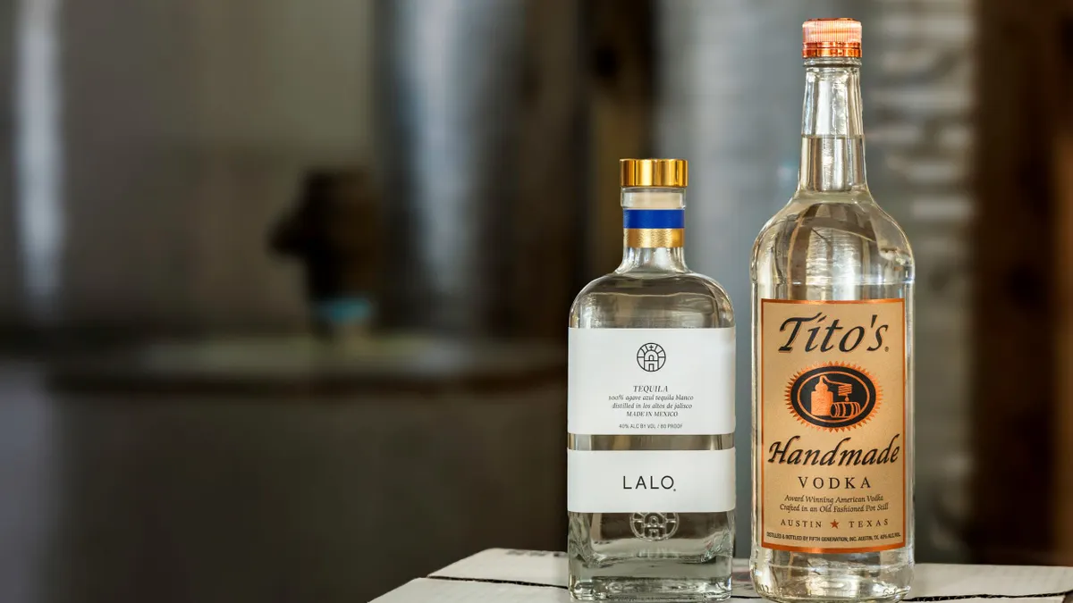 A bottle of Lalo Tequila is next to a bottle of Tito's Handmade Vodka in a product shot.