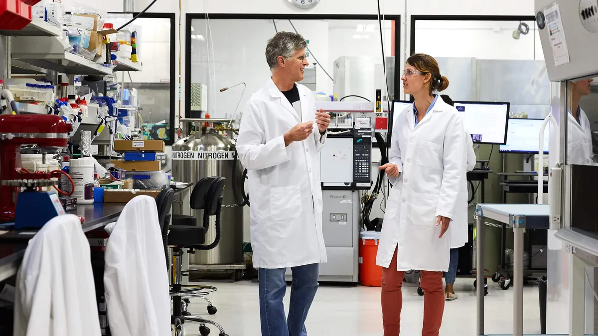 Impossible Foods founder and CEO Pat Brown, left, speaks to another scientist in Impossible Foods' research lab.