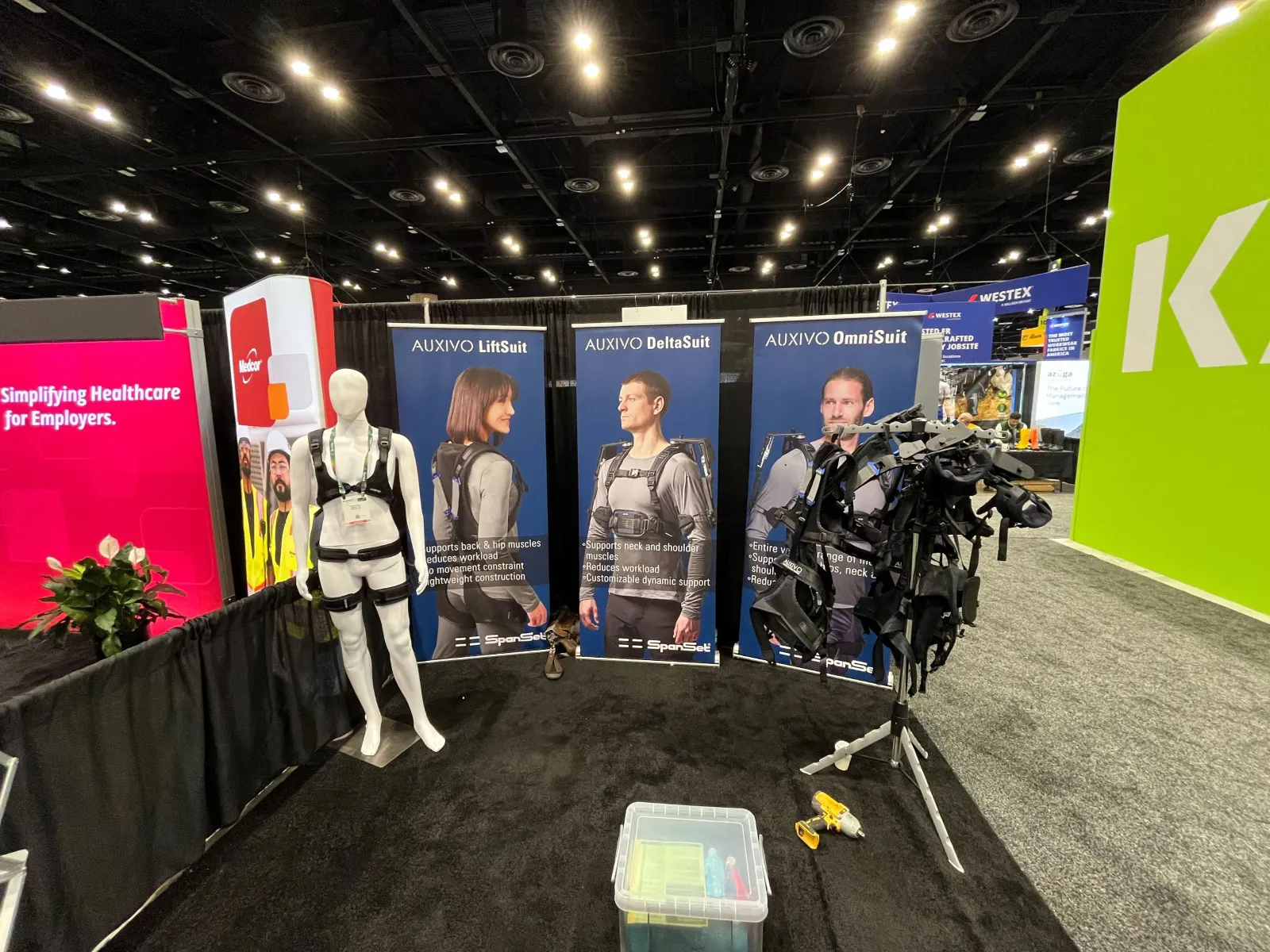A display booth at an expo hall showcases an exoskeleton suit.